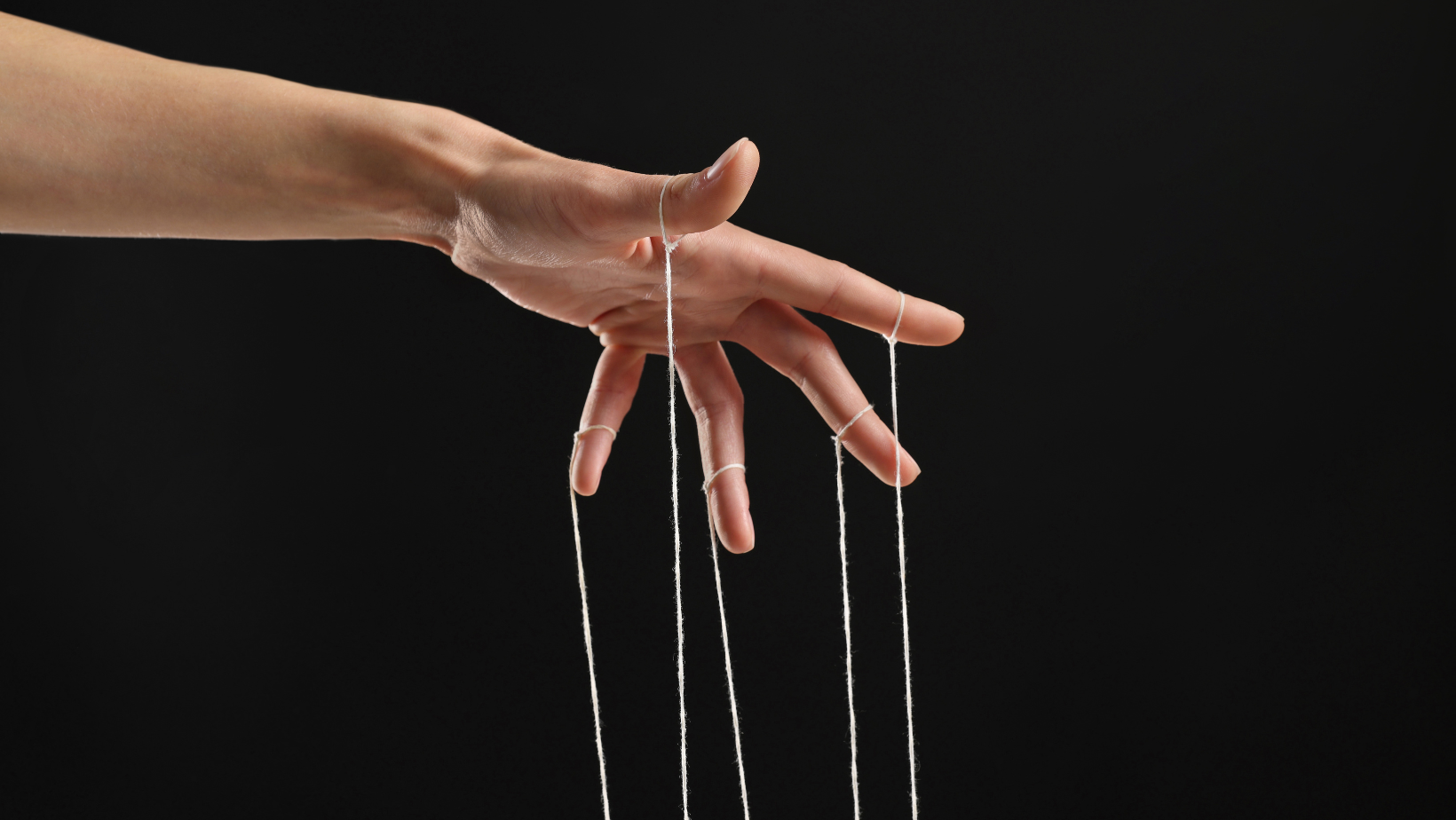 Hand hält Fäden. Suggeriert die Konditionierung in einer Hypnose
