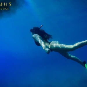 Frau schnorchelt mit grünen Flossen im blauen Meer